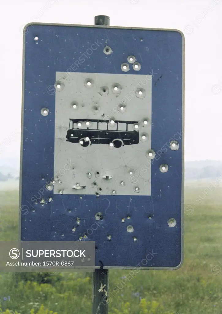 Bullet holes in bus sign 