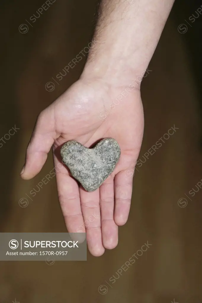 Heart shaped stone in man's hand