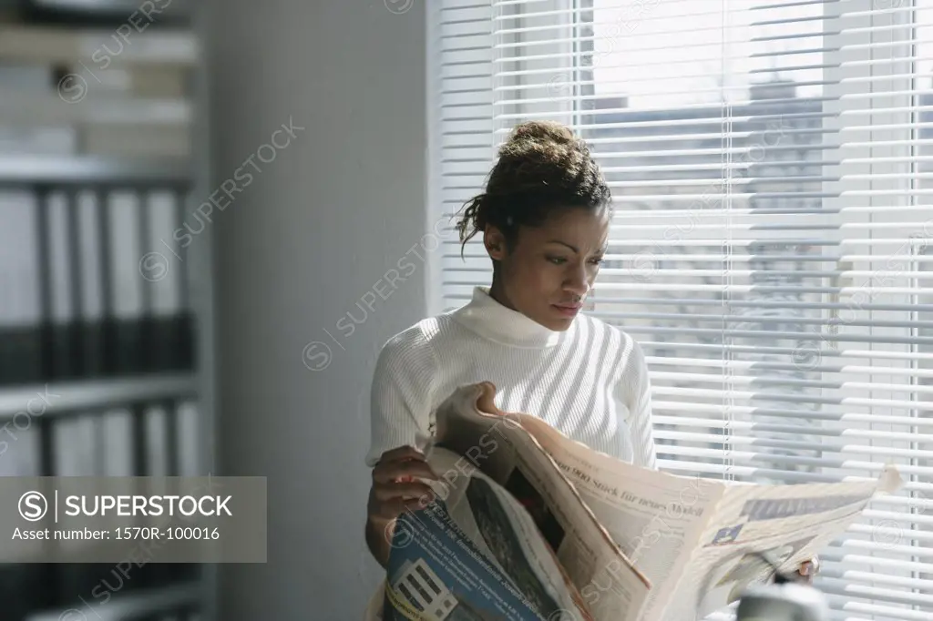 Woman reading financial newspaper
