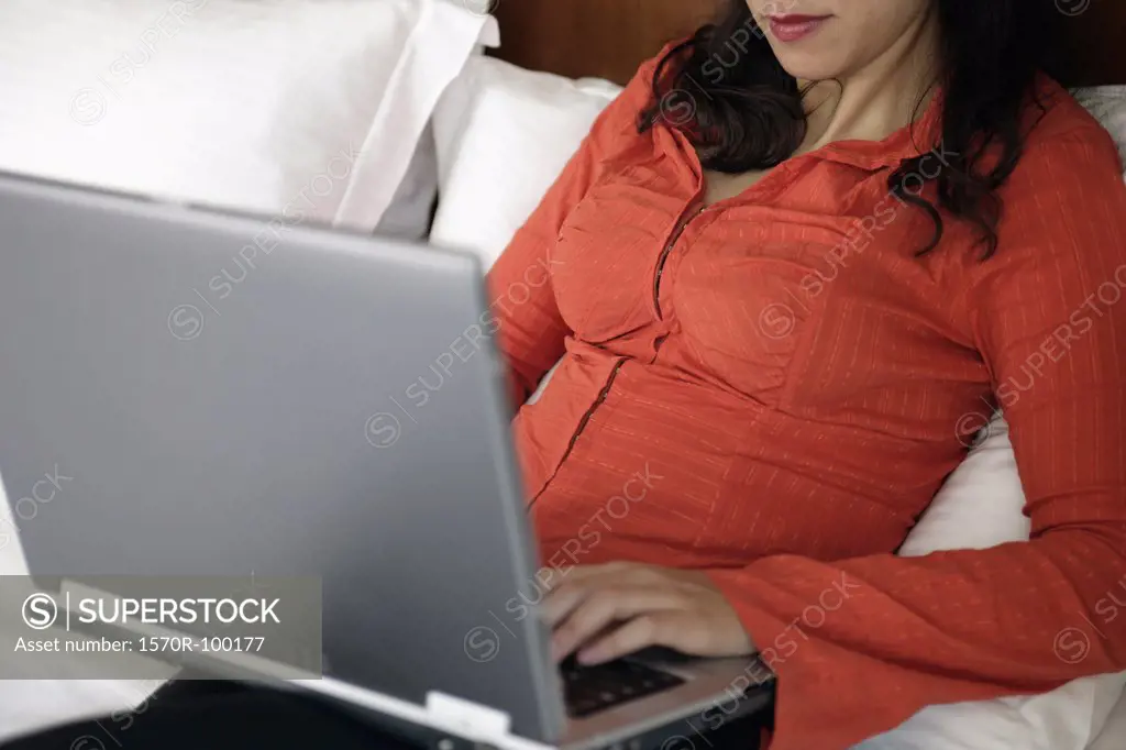 Woman using laptop computer in bed