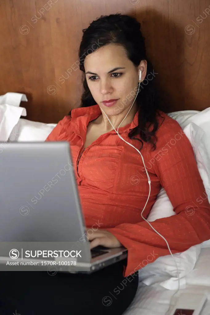 Woman with MP3 player and laptop computer