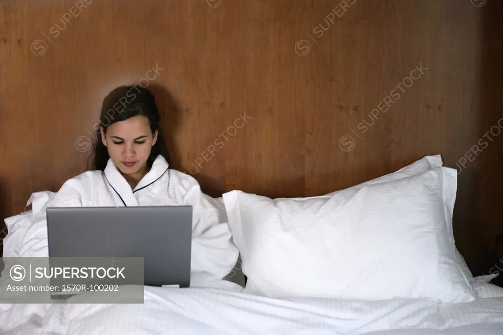 Woman using laptop computer in bed