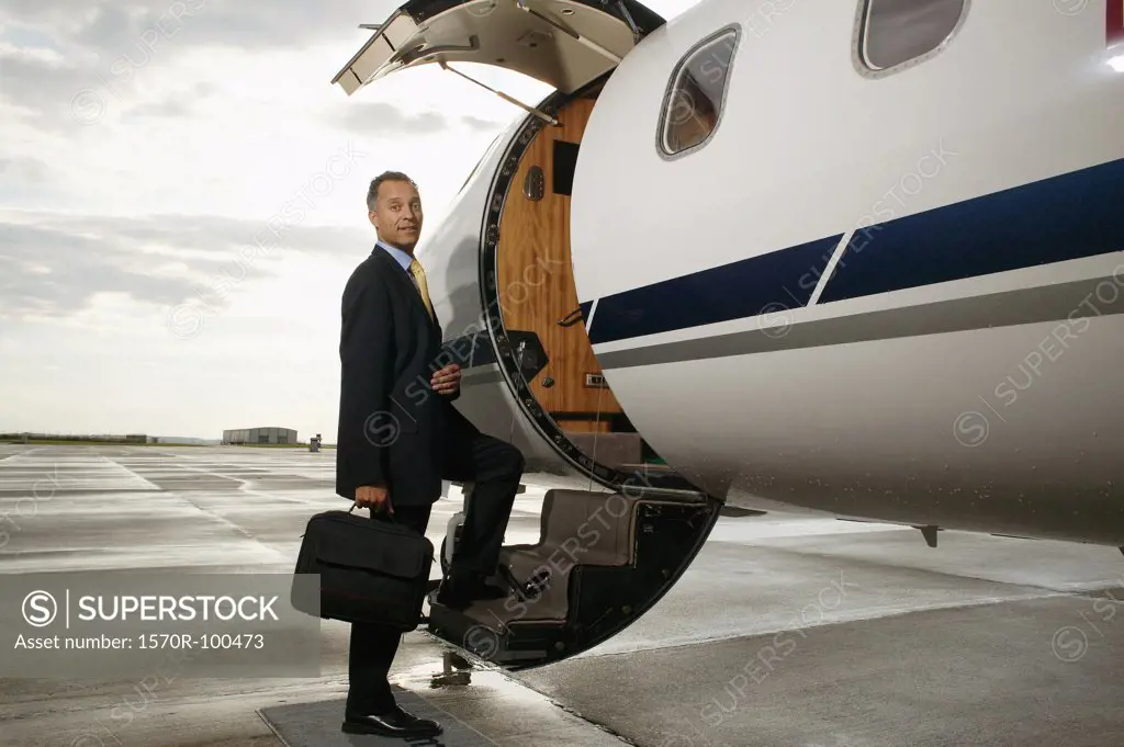 Businessman standing on a private airplanes steps