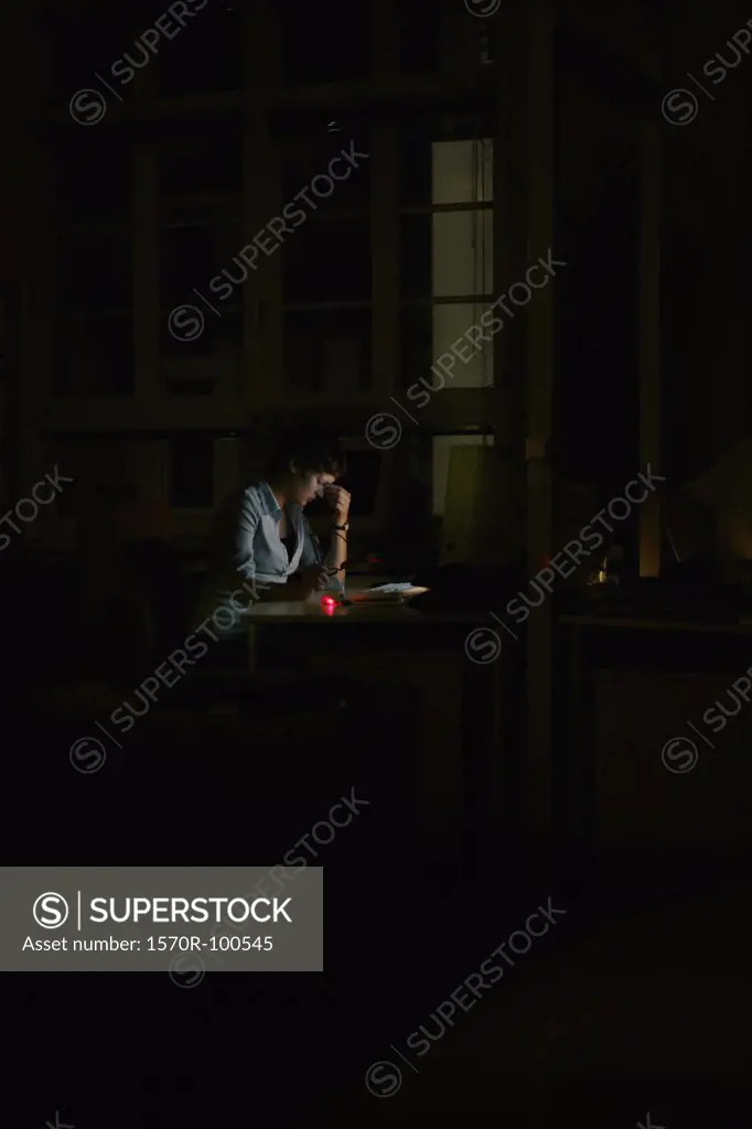 Woman sitting in the dark at a computer