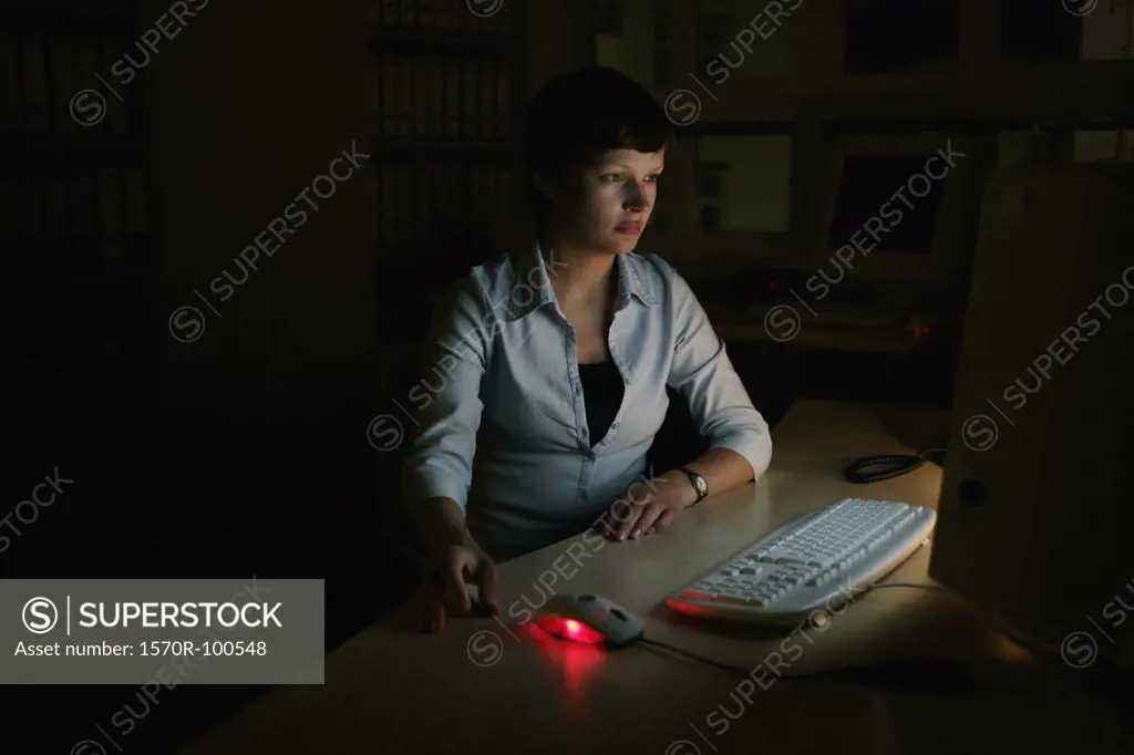 Woman using a computer in the dark