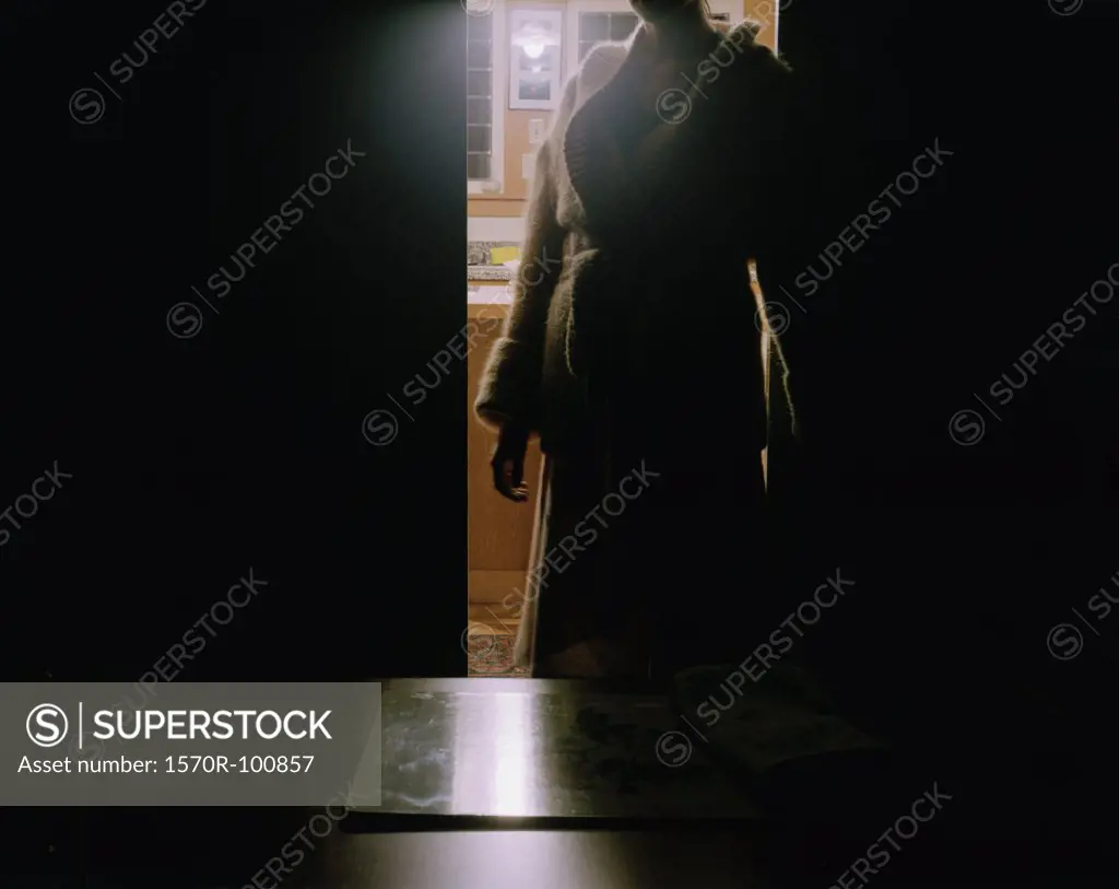 Woman standing in dark doorway