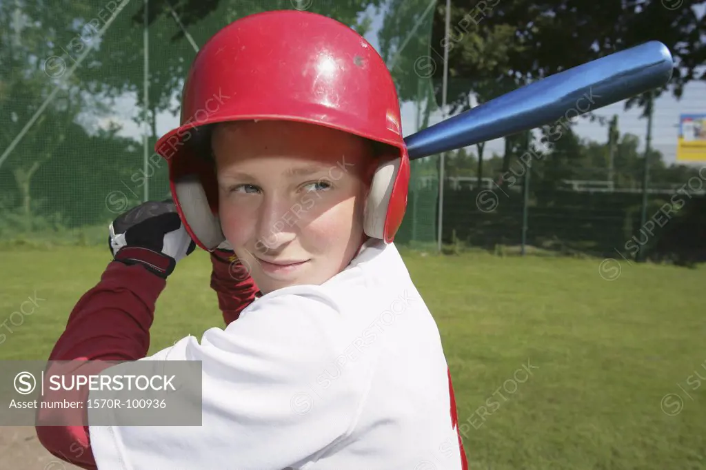 A boy in a baseball uniform holding a baseball bat