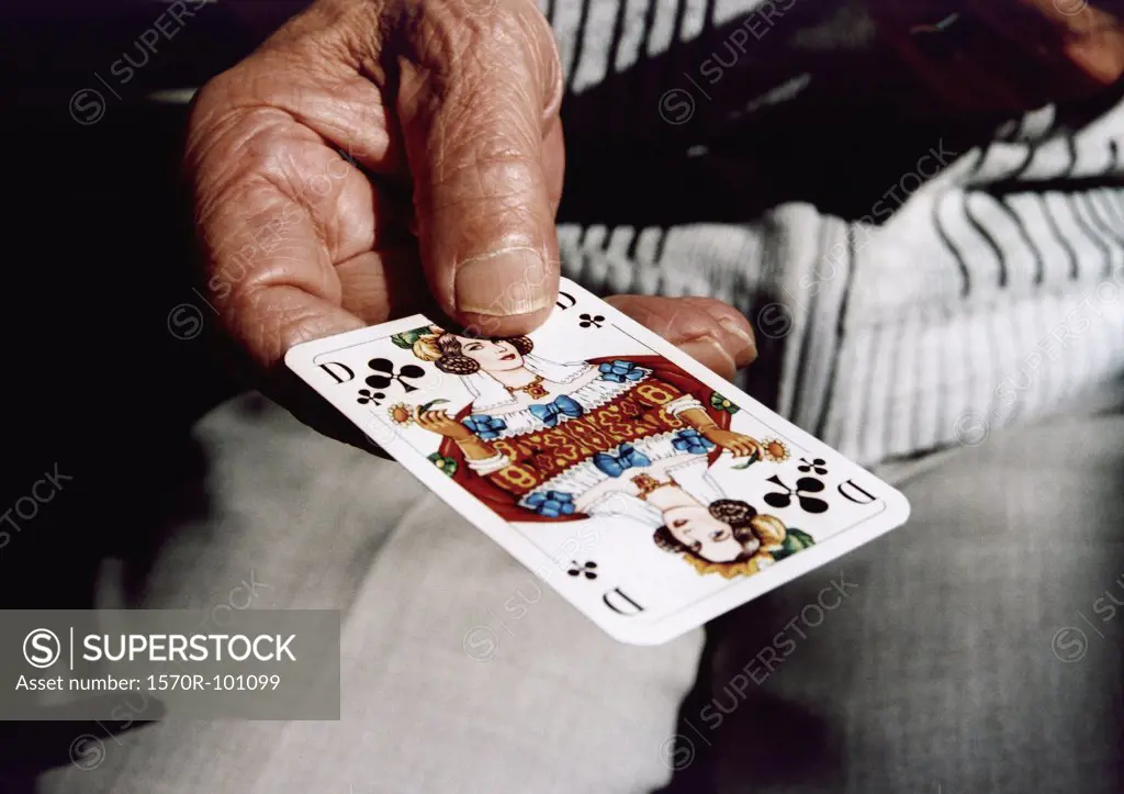 Senior man holding a playing card