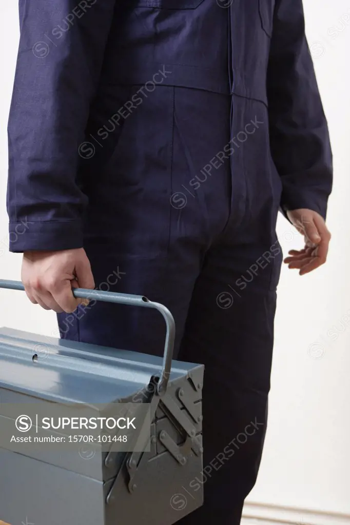 A man in a worker suit carrying a tool box