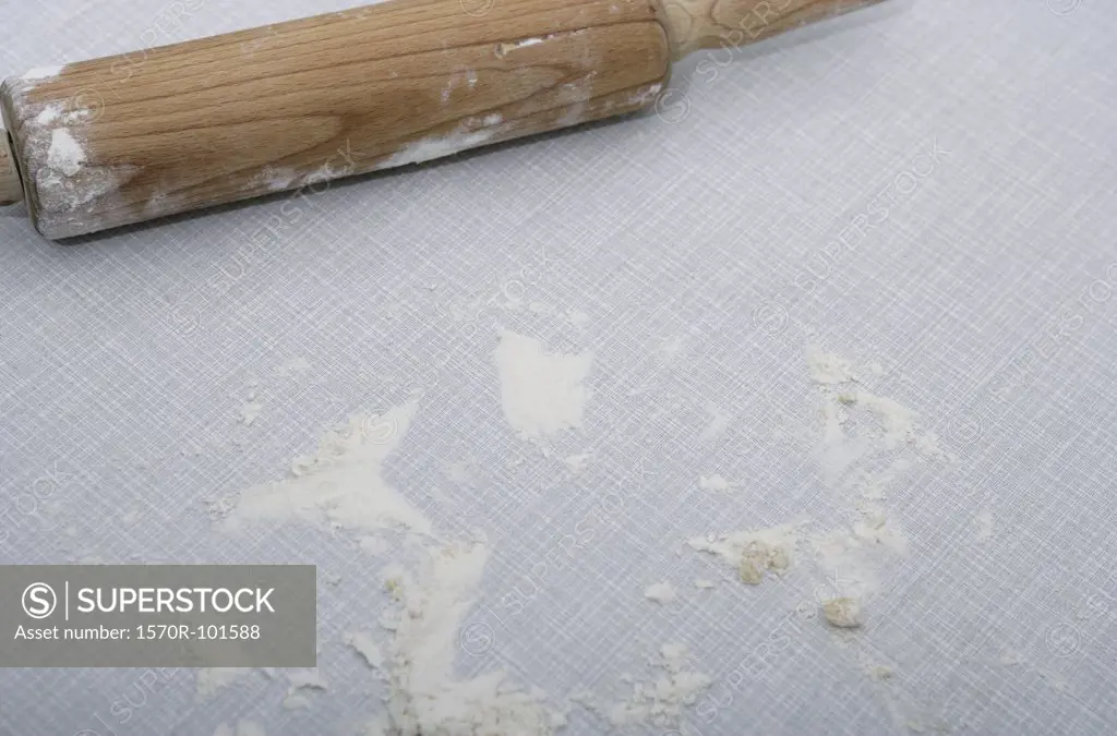 View from above of a wooden rolling pin with flour