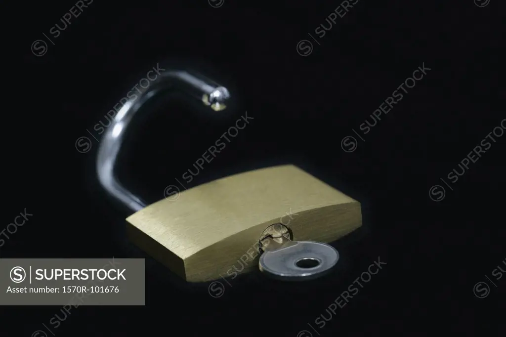 Side view of a small lock lying on a black surface