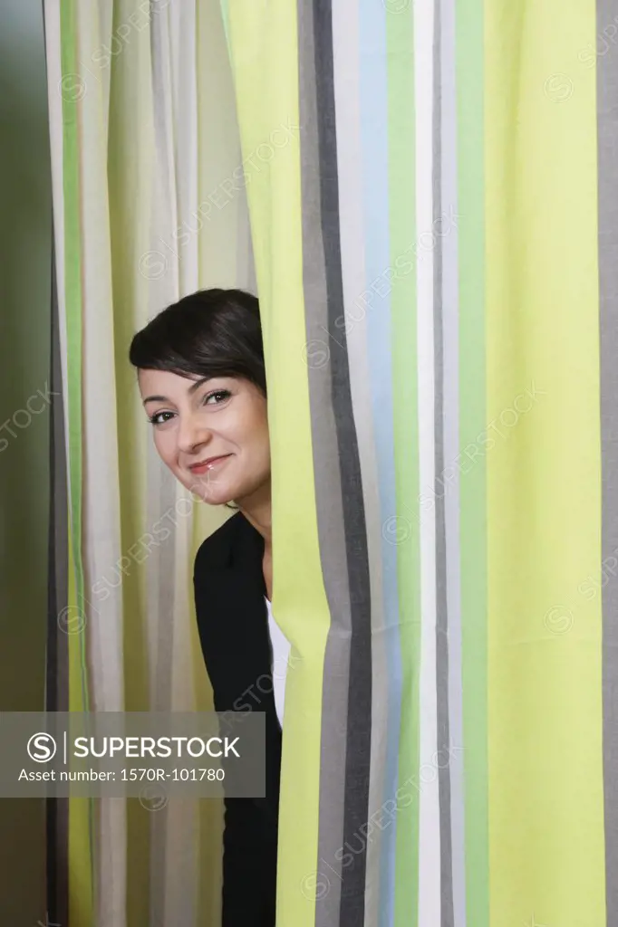 A woman looking through the curtains of a changing room