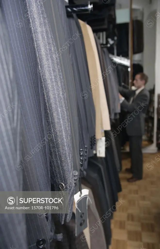 A man shopping for a suit in a clothing shop