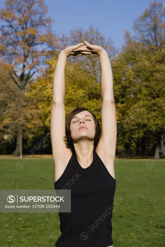 Front view of a young woman stretching her arms