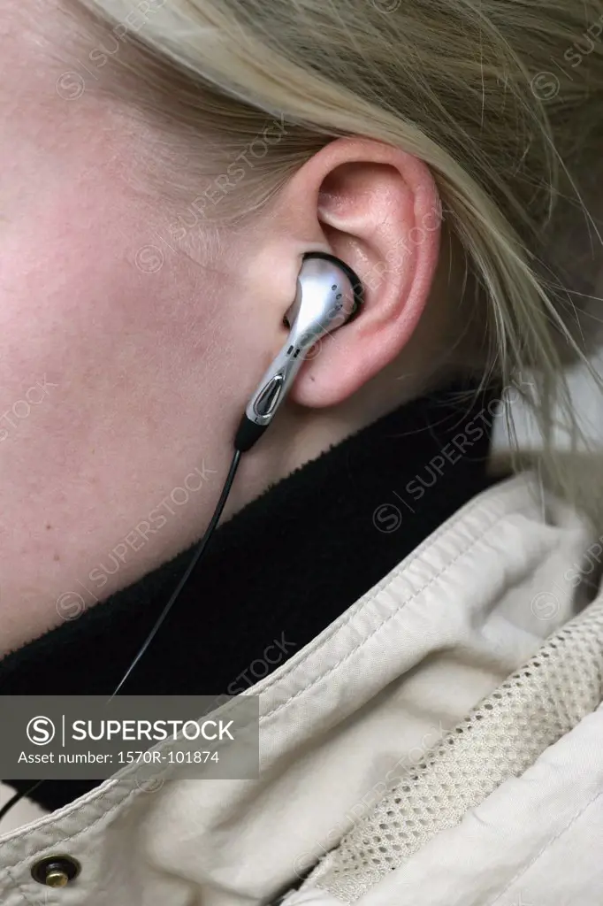 Close up of a headphone in a blond woman's ear