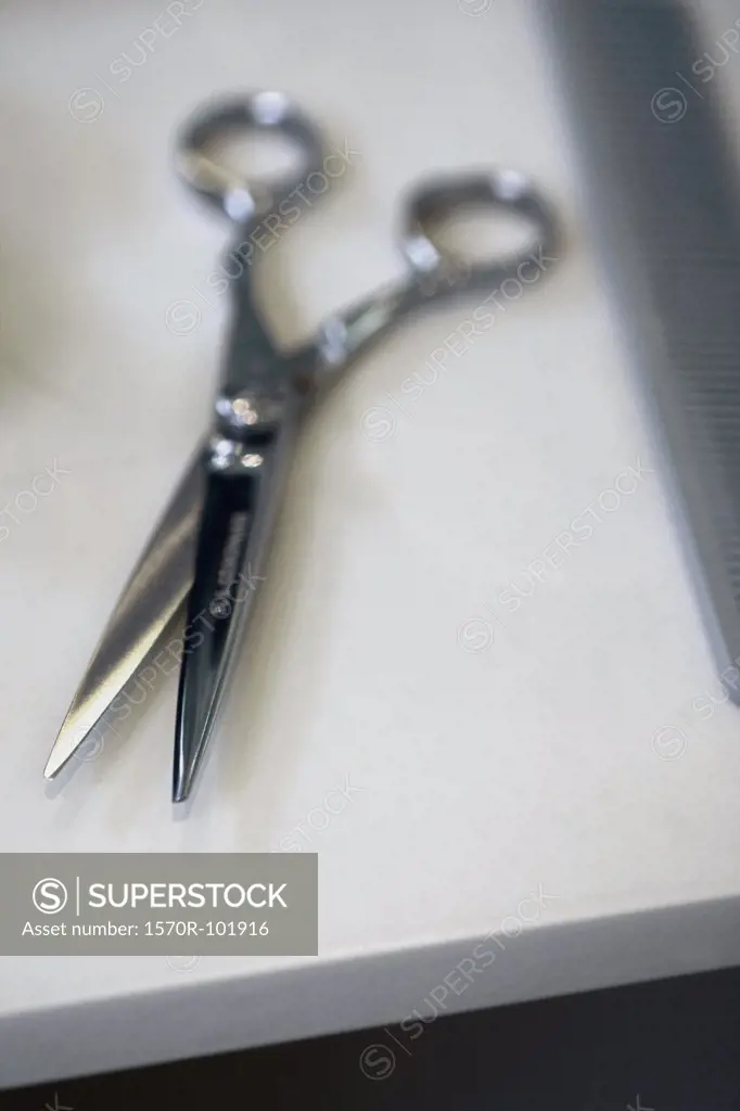 A pair of scissors and a comb on a table