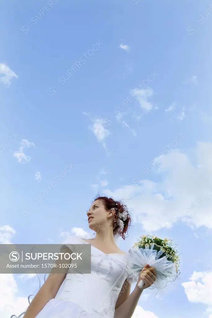 Low angle view of a bride holding a bouquet of flowers