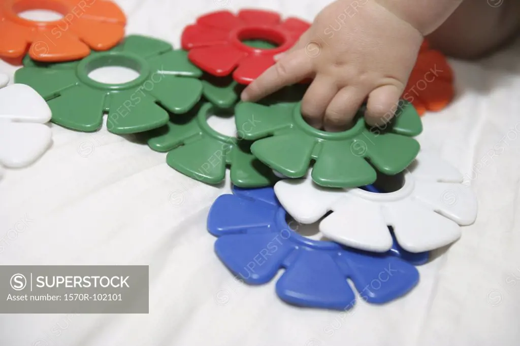 A baby playing with colorful plastic toys