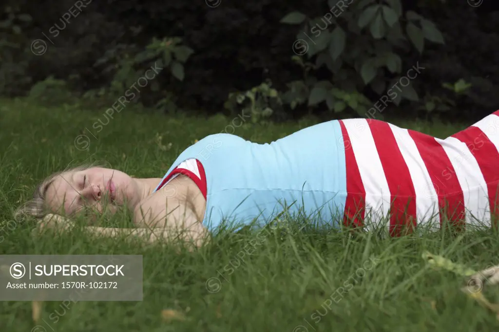A pregnant woman sleeping in the grass