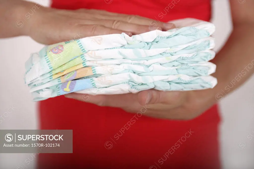 Midsection of a woman holding diapers