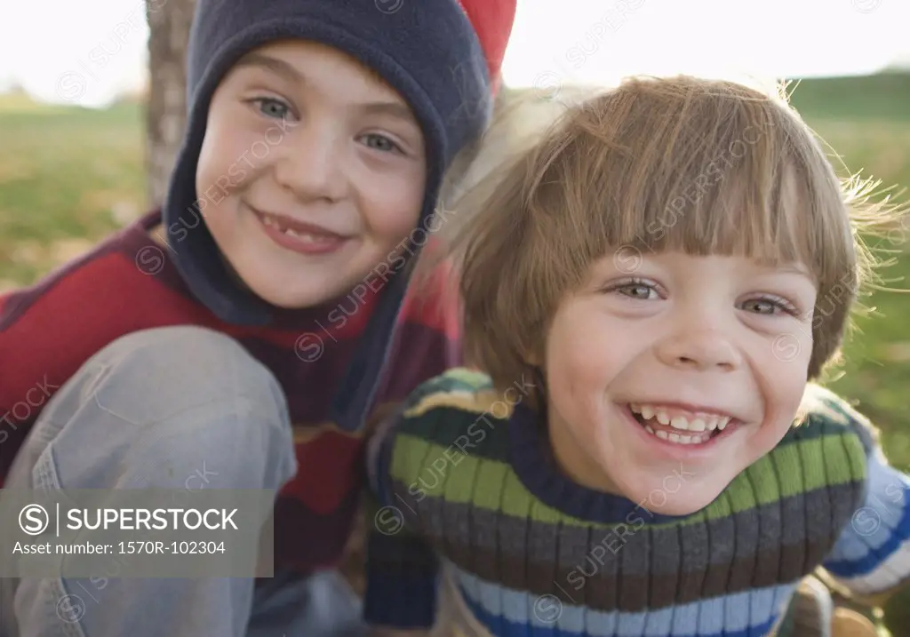 Two young boys smiling outdoors