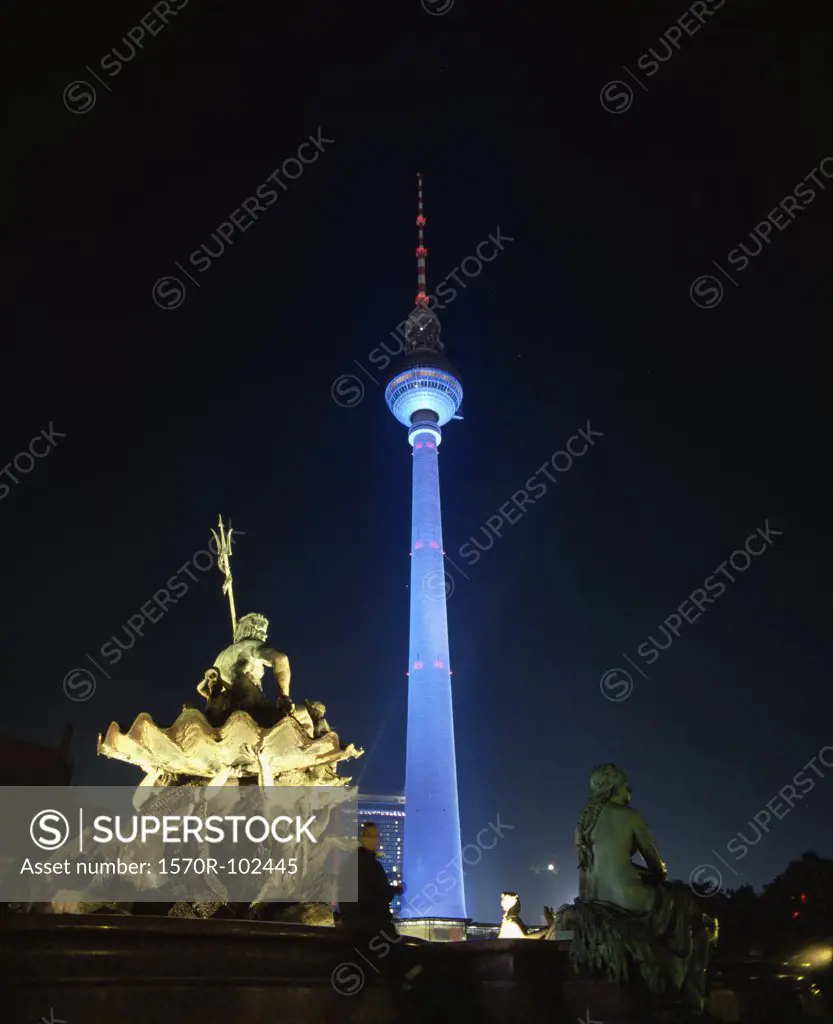 Television tower and statue of Neptune illuminated at night, Berlin, Germany