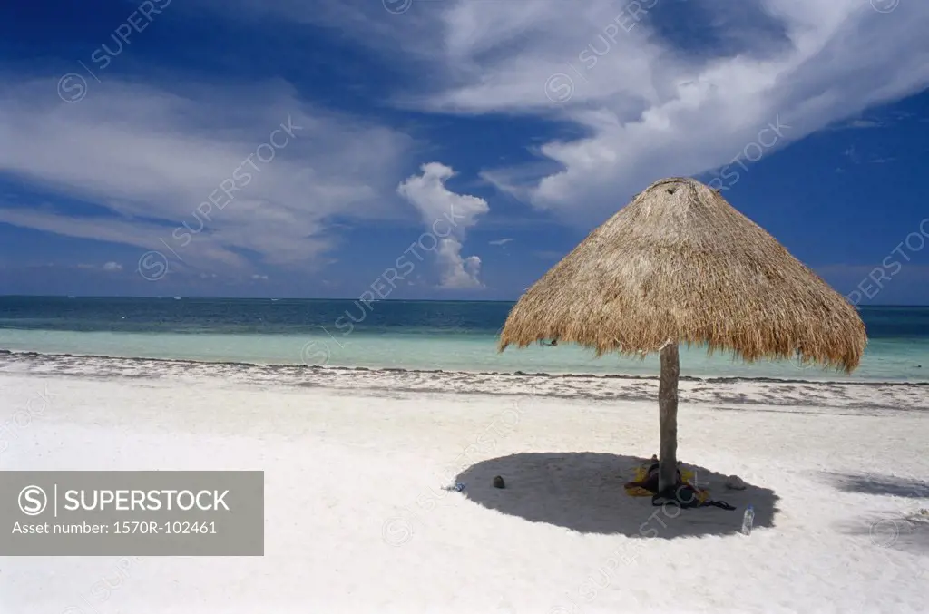 Beach scene with thatched beach umbrella, Yucatan, Mexico