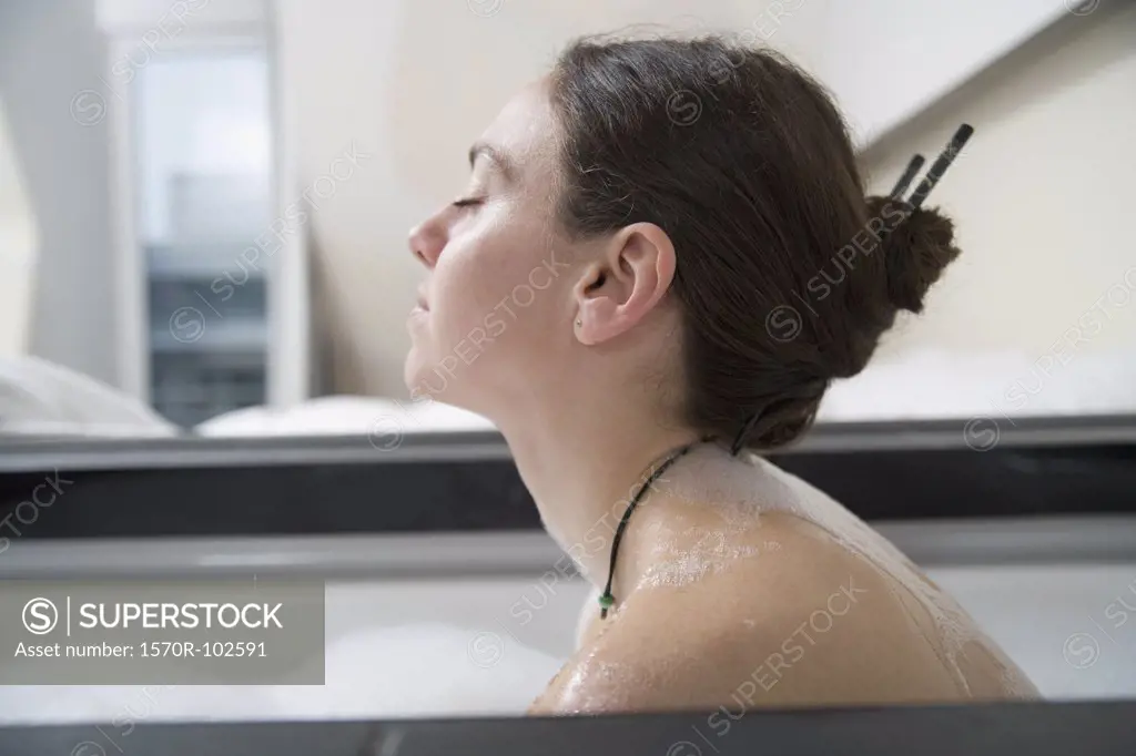 Profile of woman with brown hair in bathtub