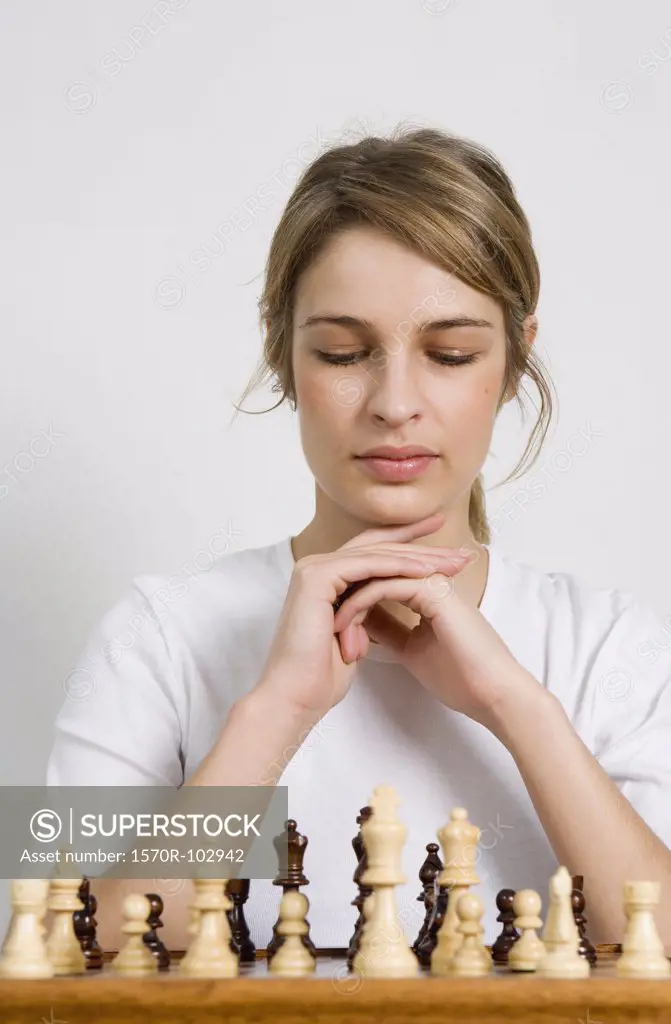 A woman looking at a chess board