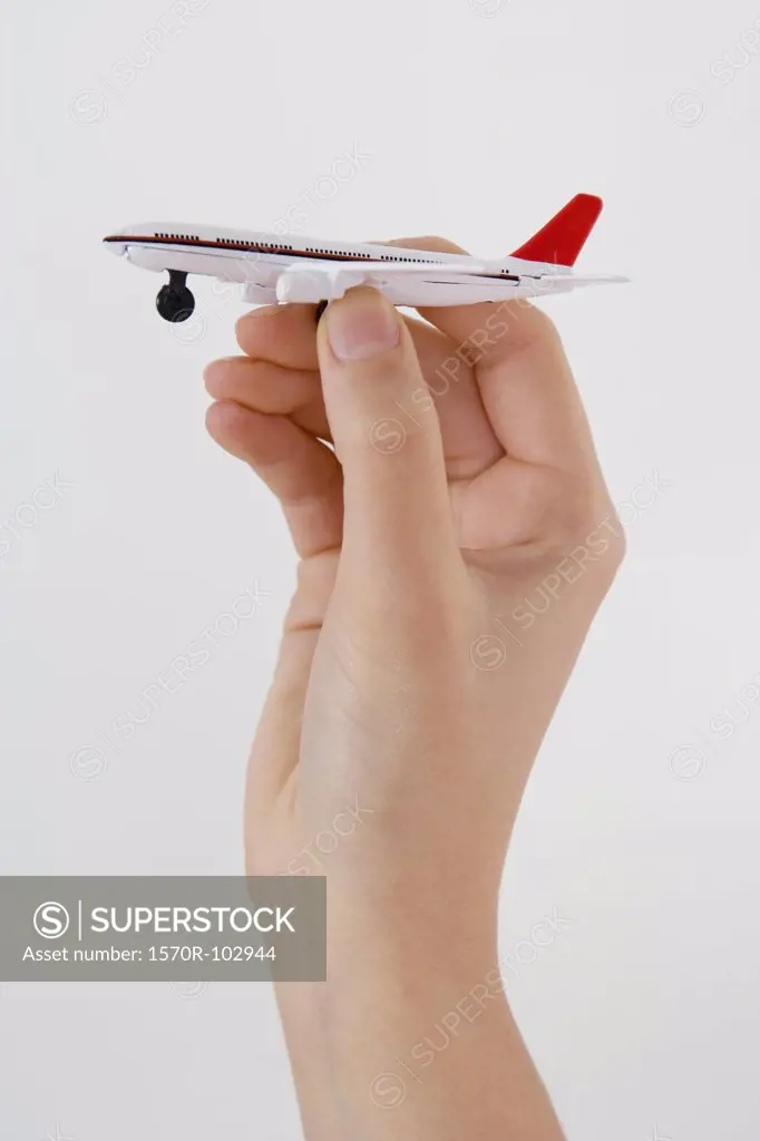 A hand holding a toy airplane