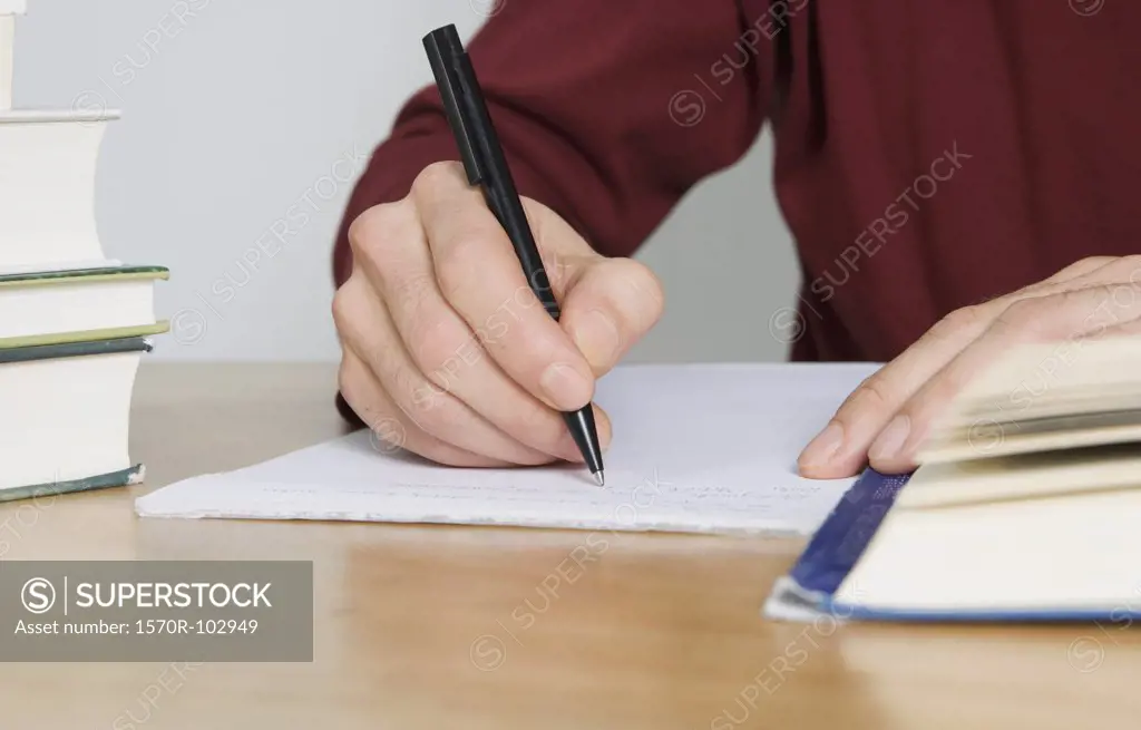 A person writing on a pad of paper