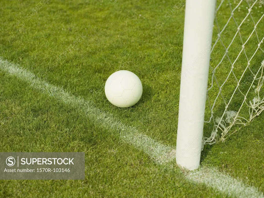 A soccer ball near a goal post