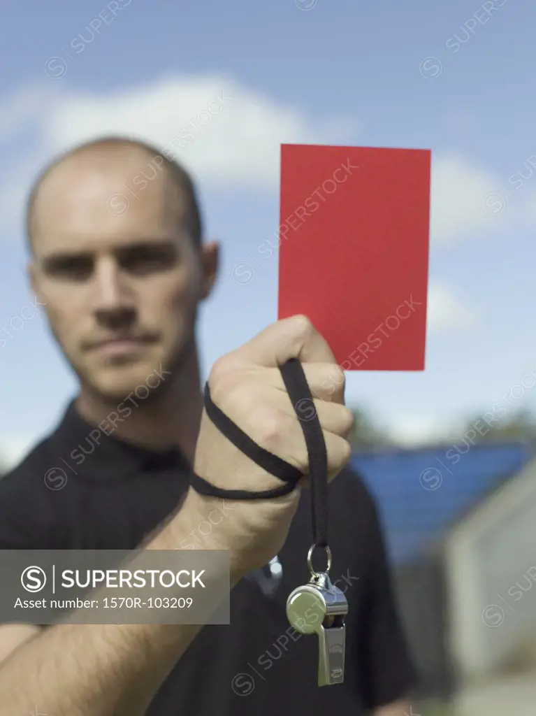 A referee holding up a red card