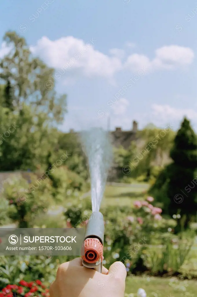 Man watering flowers with hose