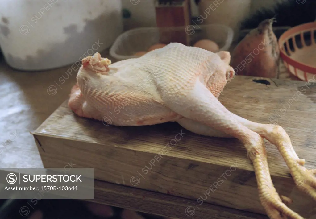 Whole chicken on wooden cutting board