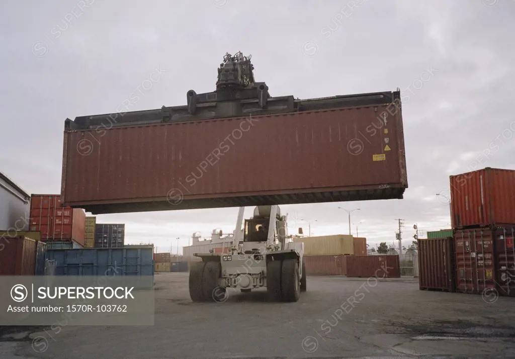 Forklift truck transporting heavy cargo container