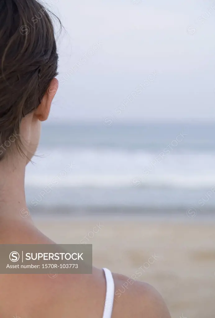 Woman on beach looking out to sea