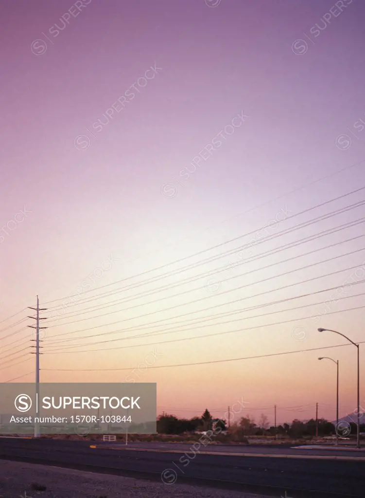 Power lines and street lights above town at sunset