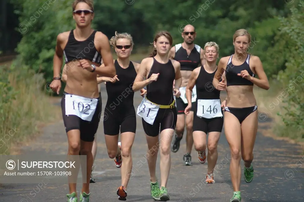 Group of people running on road in sports race