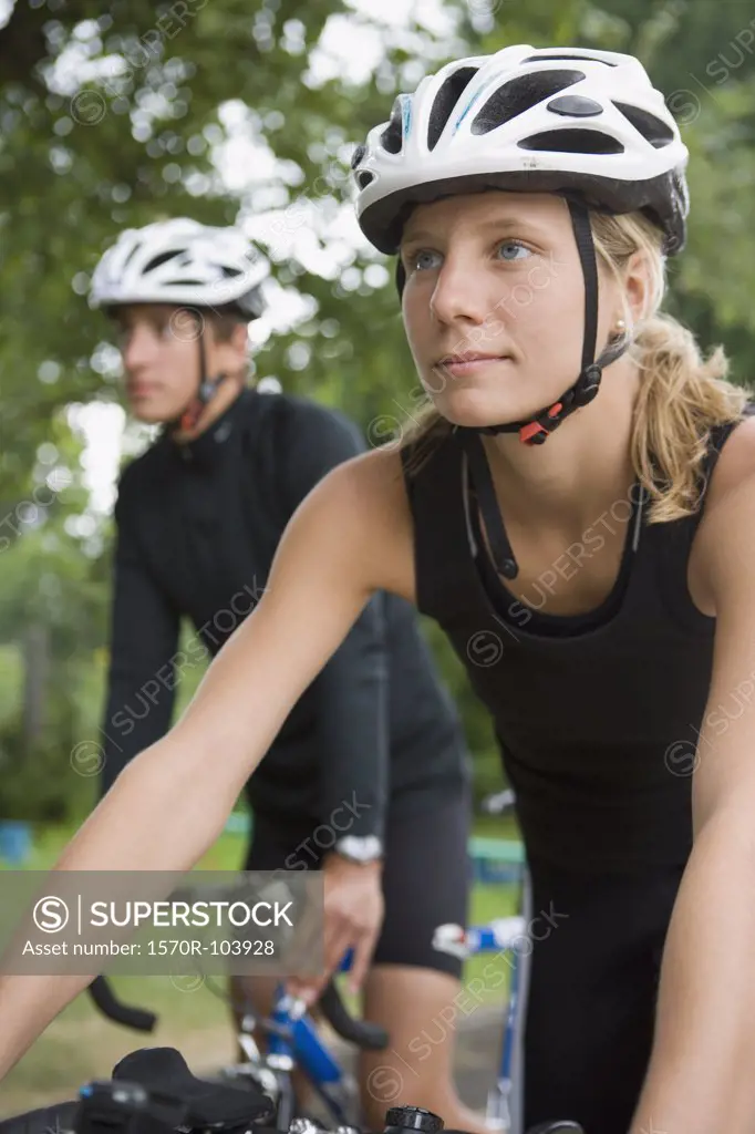 Young couple cycling through park together