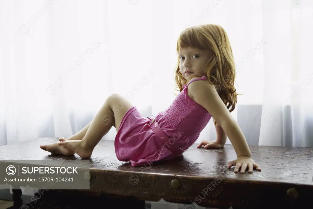 Girl sitting on desk posing