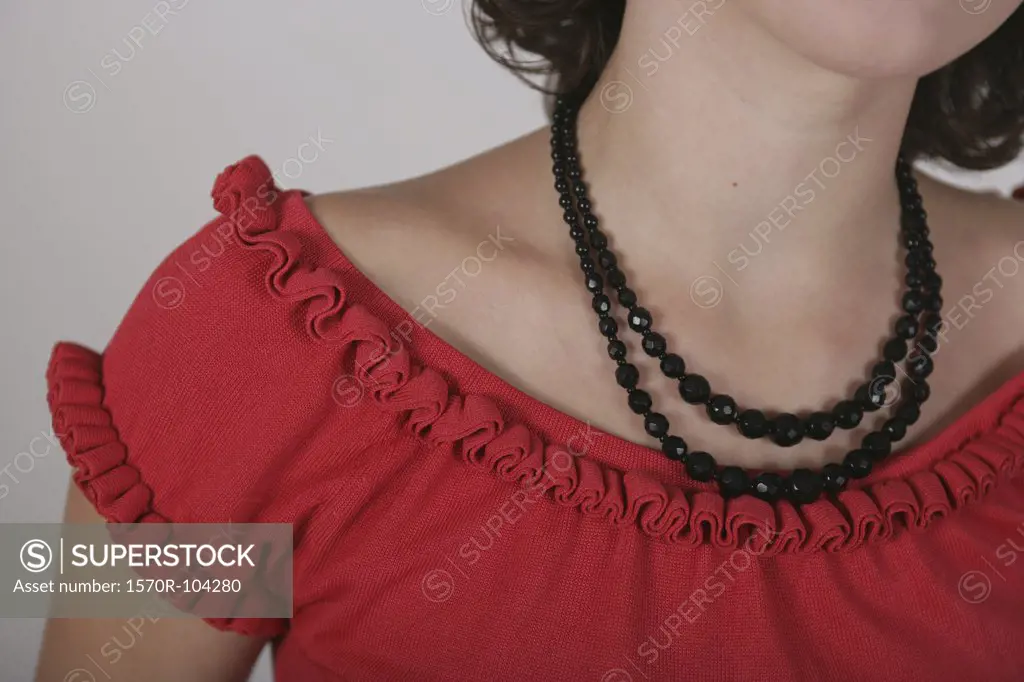 Shoulders and neck of woman wearing necklace