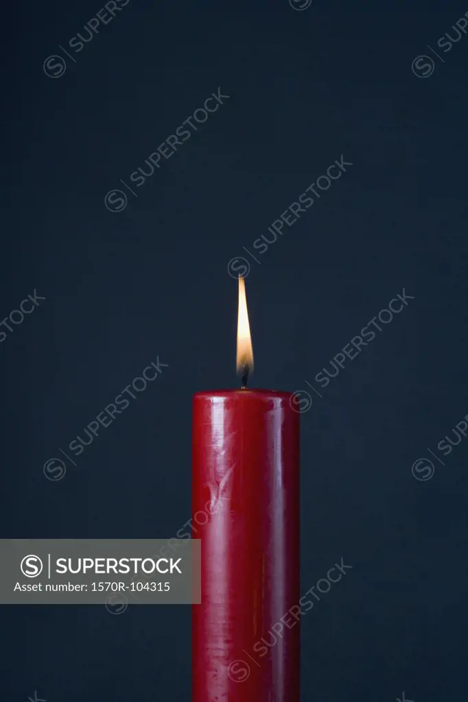 A red candle against a black background