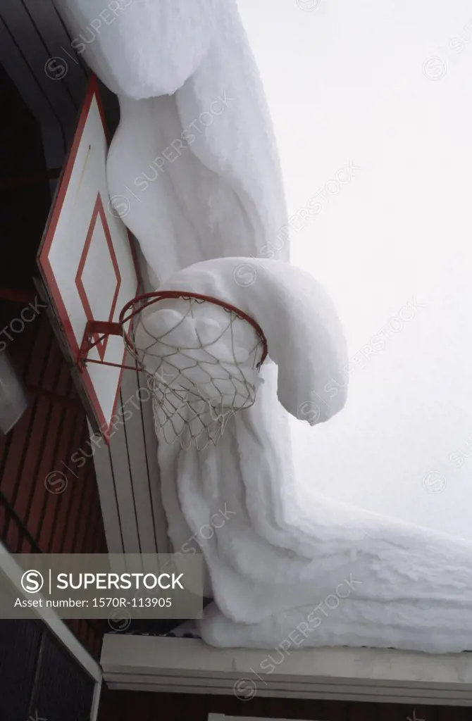 Snow covered roof and basketball ring