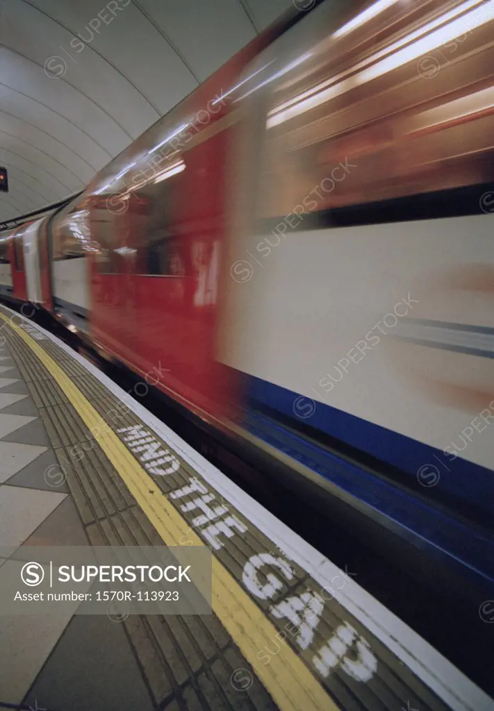 Train moving through Underground station, London, England