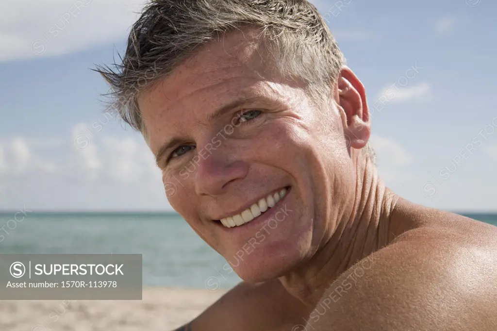 Man sitting on the beach and smiling
