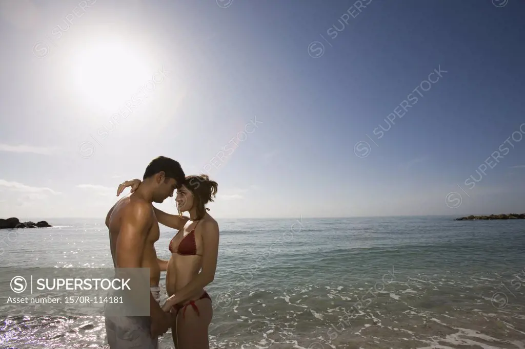Young couple embracing in front of the sea