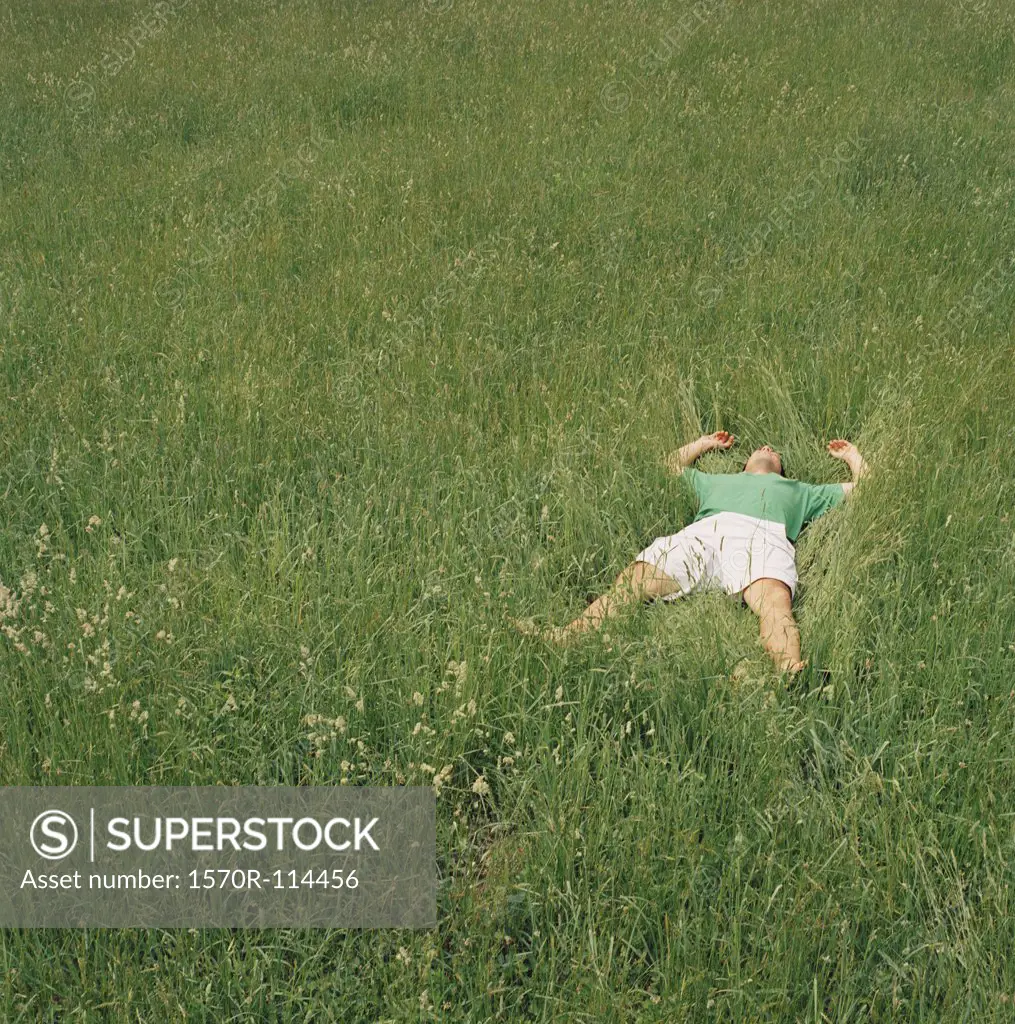 Man lying down in field of grass