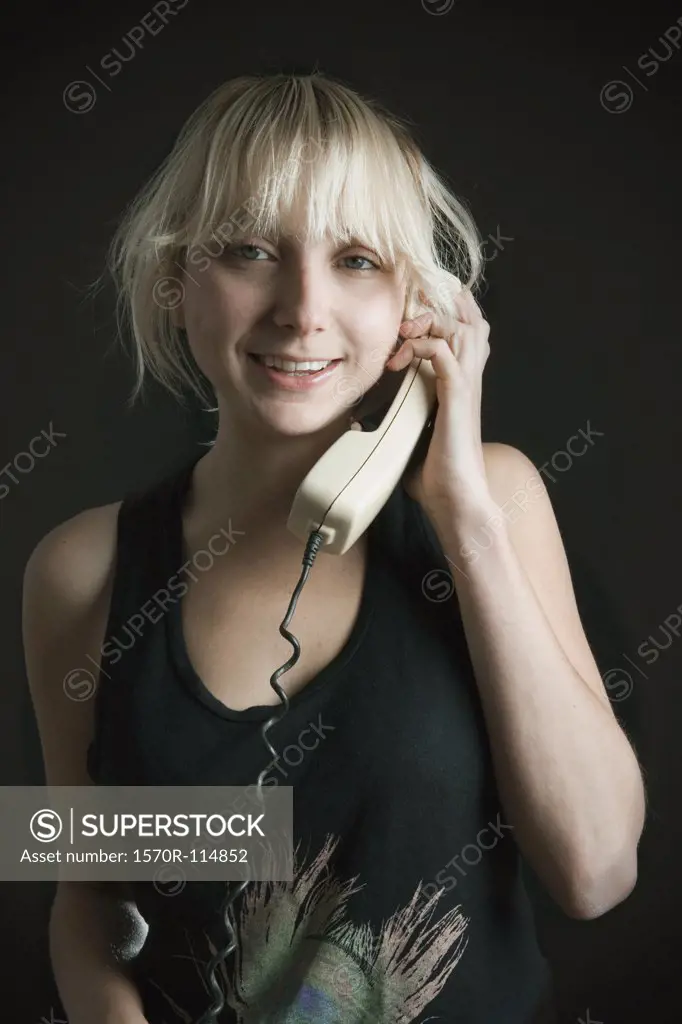 Young woman using landline telephone