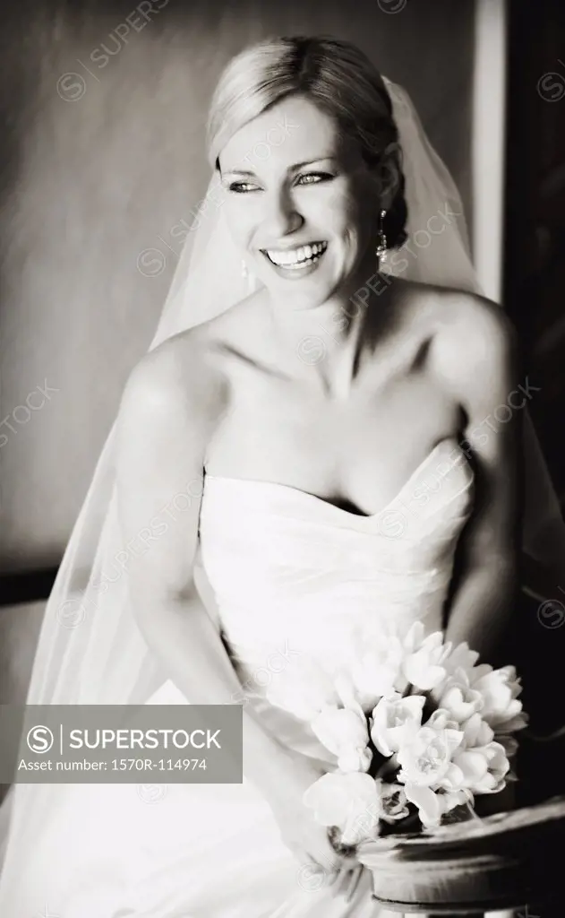Portrait of bride holding wedding bouquet and looking away
